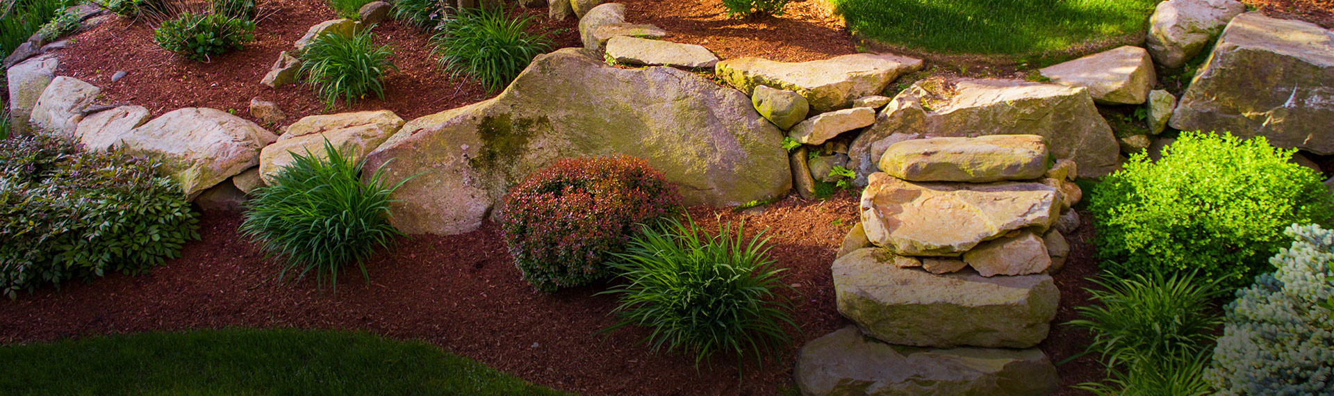 Landscaped flower bed with red mulch